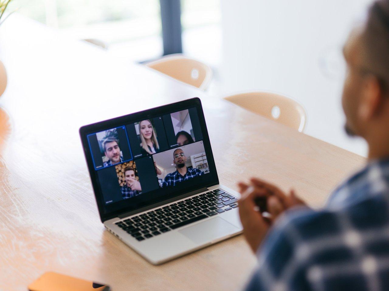 Réunion d’équipe commerciale en visioconférence multi-sites, analysant des tableaux de données pour l’alignement tactique.