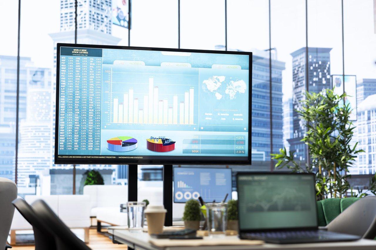 Un business meeting avec un tableau de bord numérique affichant les indicateurs de performance.