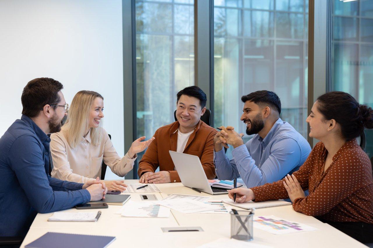 Une équipe commerciale diverse collaborant autour d’un tableau digital CRM et de KPIs en temps réel pour optimiser la stratégie de vente.